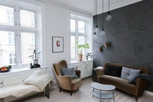 salón decorado modernamente con paredes blancas y una pared en gris oscuro
